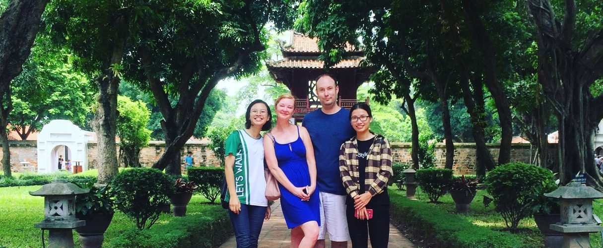 Family of travellers with their guide in the gardens of the Temple of Literature