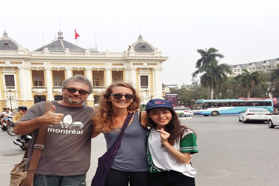 Guide and two travellers in front of the yellow Hanoi Opera House