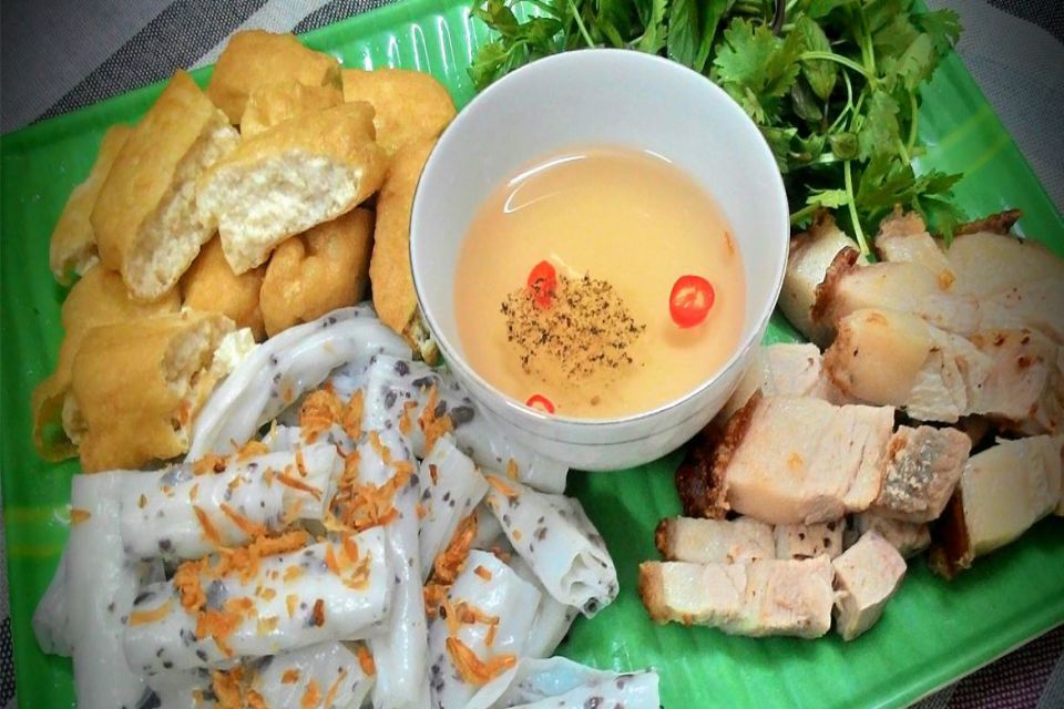 Plate of banh cuon and fried pillow cakes with a bowl of dipping sauce on banana leaf