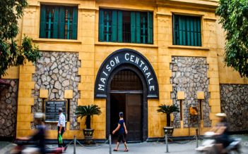 Yellow street facade of Hoa Lo Prison with its Maison Centrale doorway
